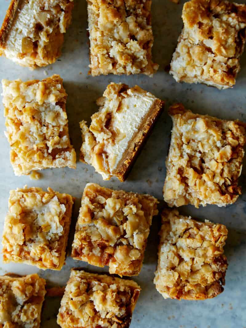 Individual streusel topped apple pie cheesecake bars.