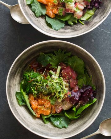 Korean spicy sashimi salad in gray bowls.
