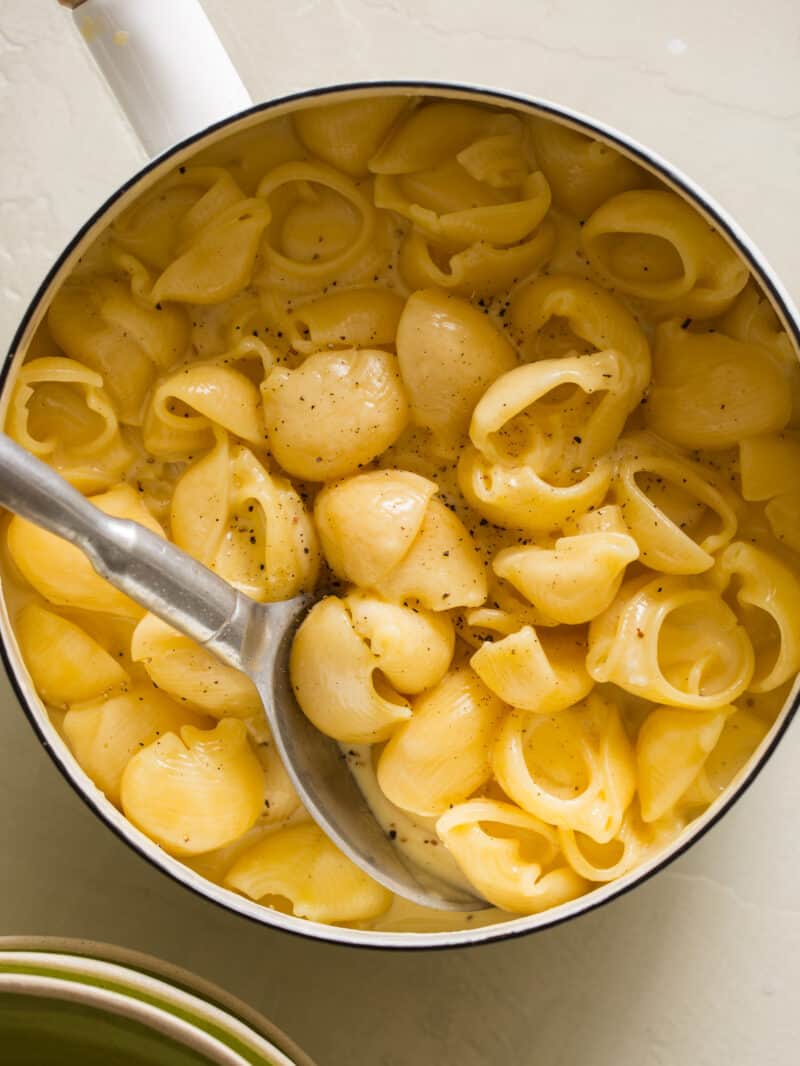 Stovetop mac and cheese in a skillet with a spoon in it. 