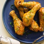 Crispy baked teriyaki drumsticks on a plate.