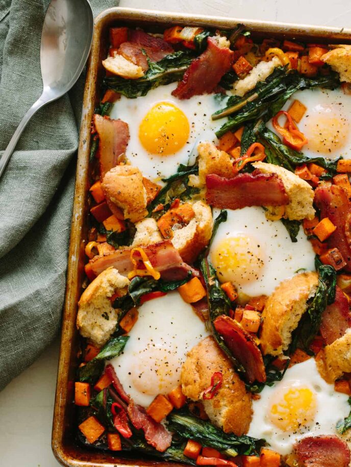 A close up of a savory breakfast pan with linens and a spoon.