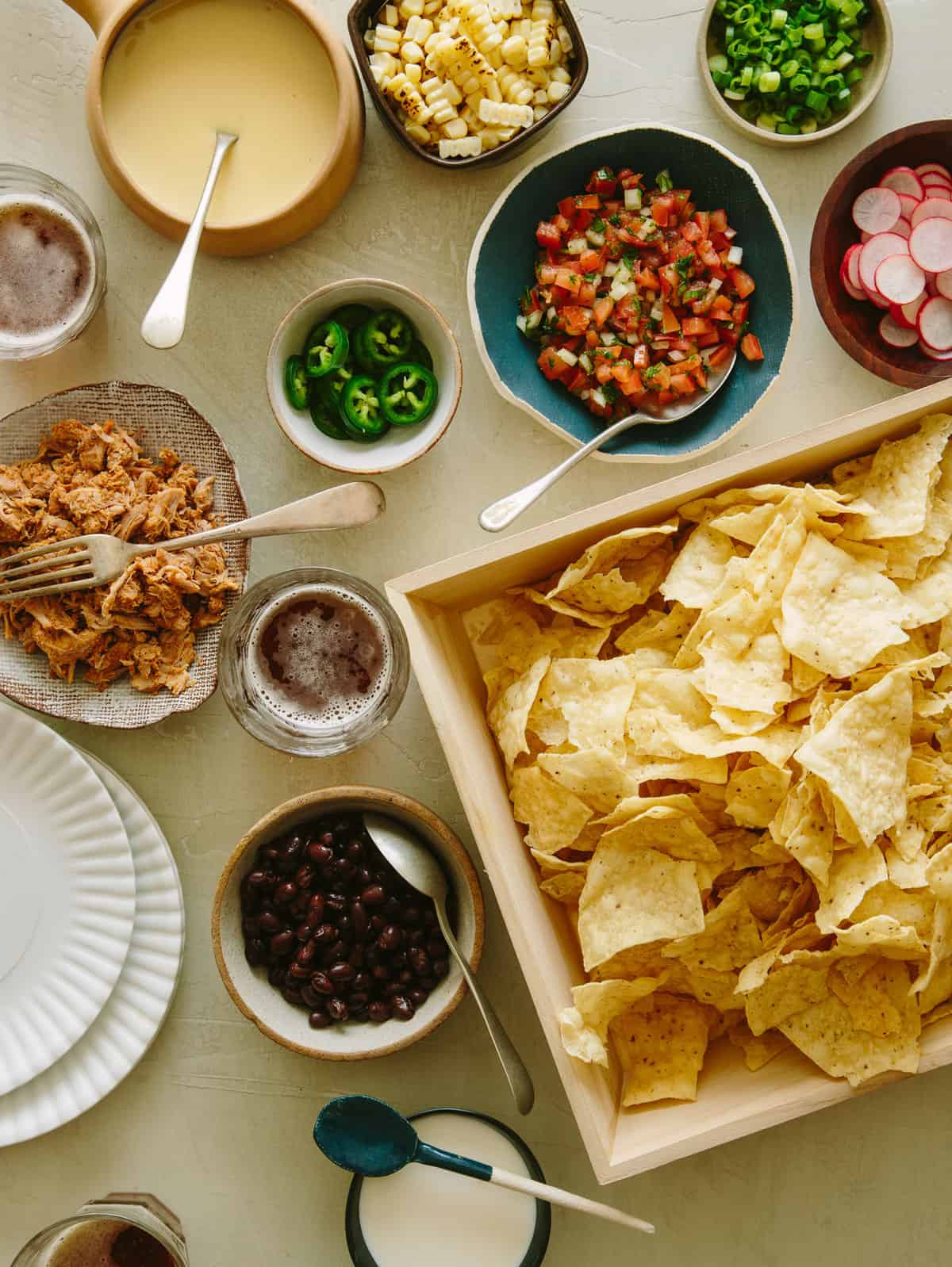 Chips in a tray and toppings in different bowls for DIY nacho bar for Super Bowl. 