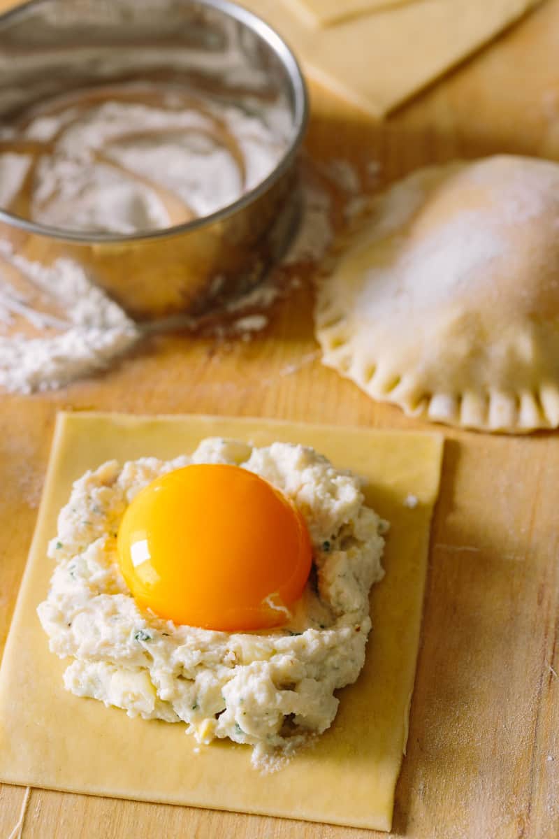 A close up of half complete chicken and tarragon poached yolk stuffed ravioli.