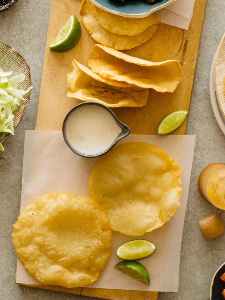 DIY hard and puffy corn tortillas, flat and folded on a cutting board.