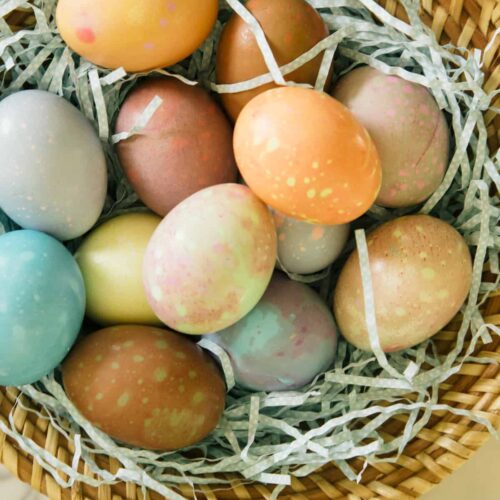 A close up of spotted Easter eggs in a basket.