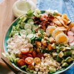 A plate of southwestern style cobb salad with cilantro ranch dressing on the side.