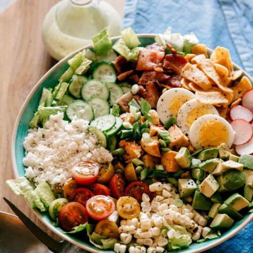 A plate of southwestern style cobb salad with cilantro ranch dressing on the side.