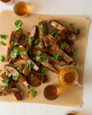 Mango habanero glazed spare ribs garnished with cilantro and extra glaze on the side.