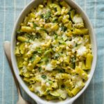 Baked chicken rigatoni with sweet corn, zucchini, and a roasted poblano béchamel with a spoon.