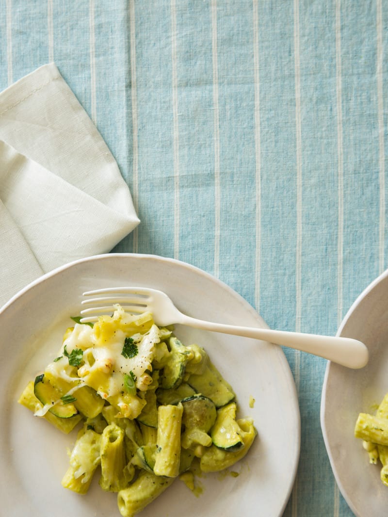 Baked chicken rigatoni with sweet corn, zucchini, and a roasted poblano béchamel on plates.