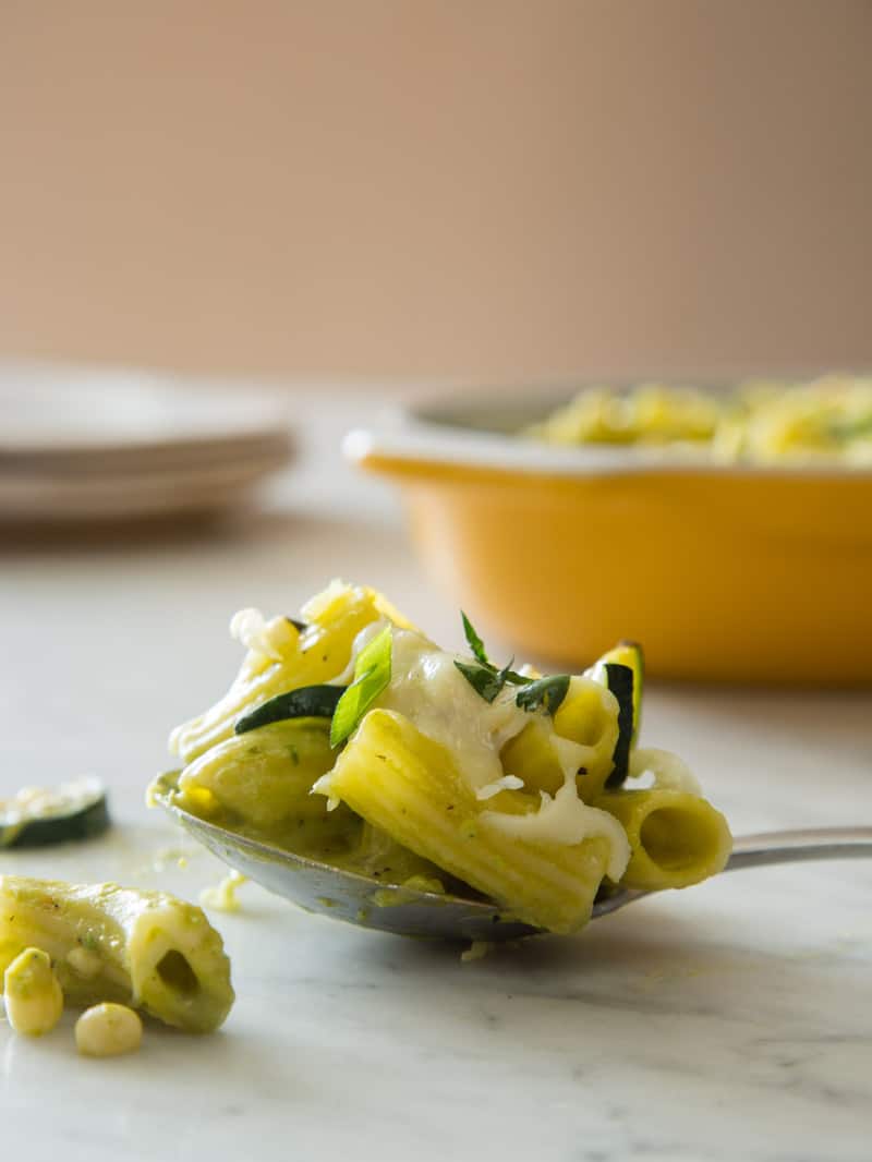 Baked chicken rigatoni with sweet corn, zucchini, and a roasted poblano béchamel on a spoon.