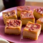 A plate of peanut butter and jelly cheesecake bars with potato chip crust.