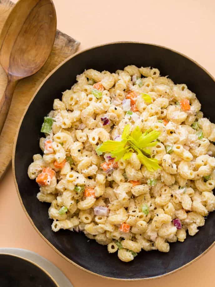 A bowl of Hawaiian style macaroni salad with a wooden spoon.
