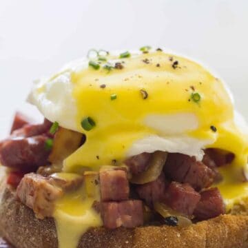 A close up of corned beef hash eggs benedict.