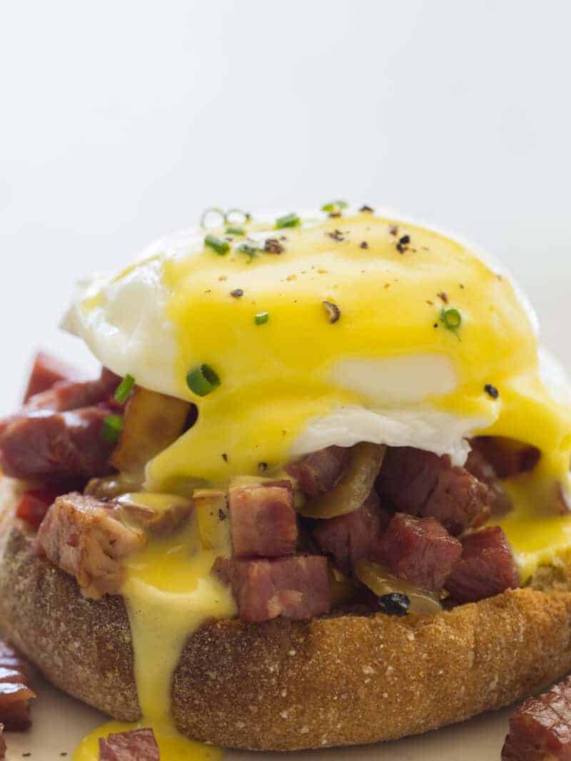 A close up of corned beef hash eggs benedict.