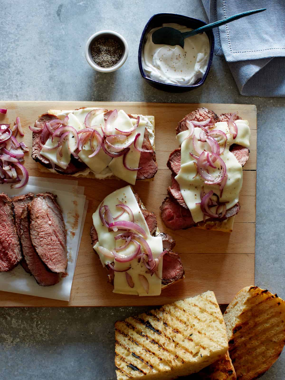 An assembly line for making tri tip sandwiches with all of the ingredients.