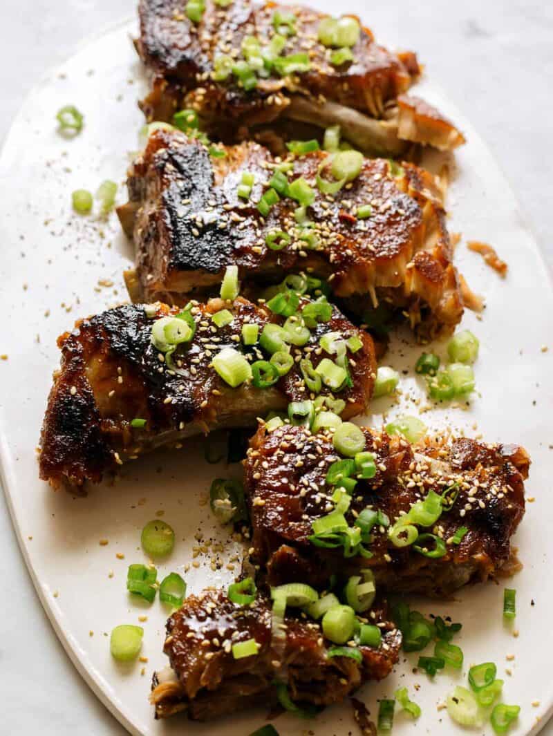 Close up of honey hoisin baby back ribs garnished with green onions.