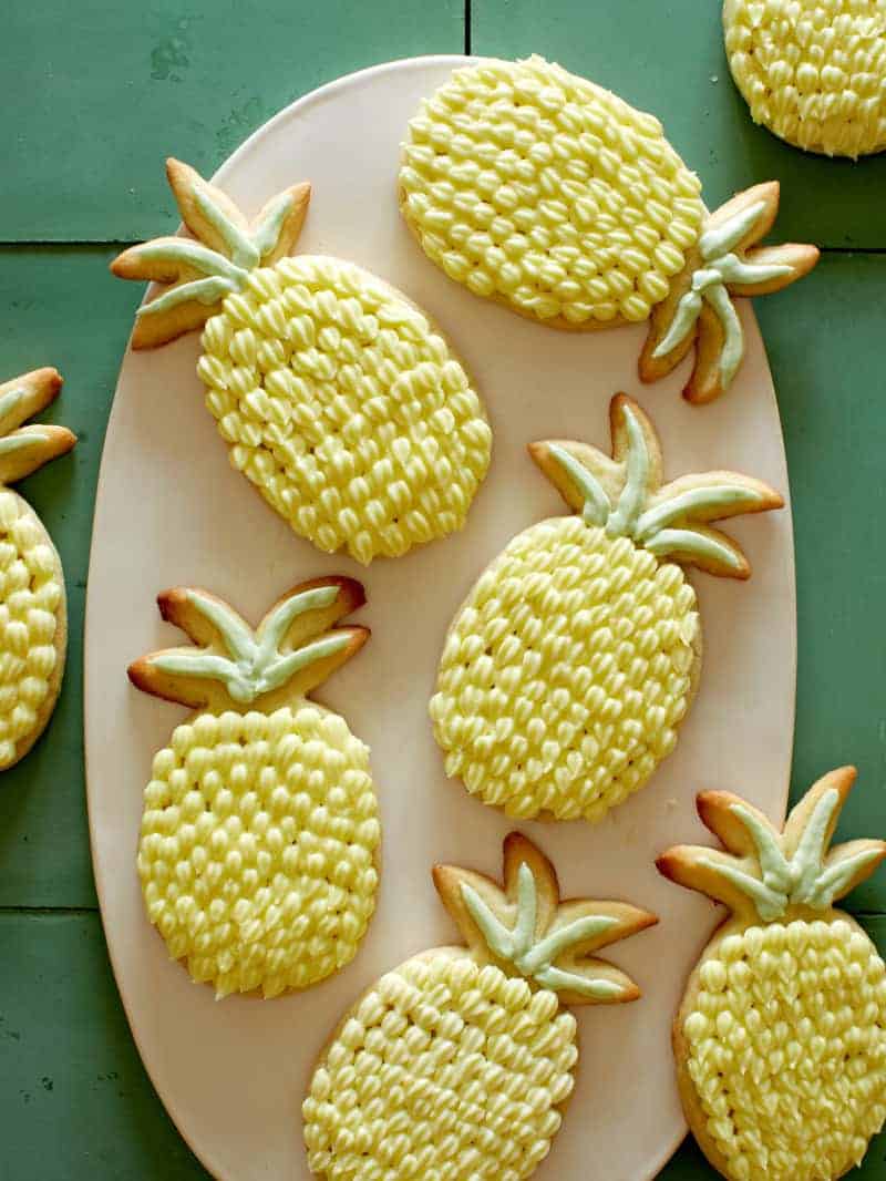 Lime sugar cookies with pineapple buttercream on a platter.