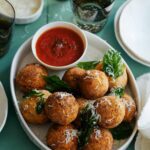 Mozzarella stuffed chicken parmesan meatballs with marinara sauce on the side.