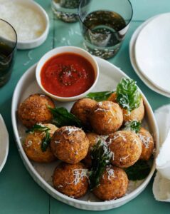 Mozzarella stuffed chicken parmesan meatballs with marinara sauce on the side.