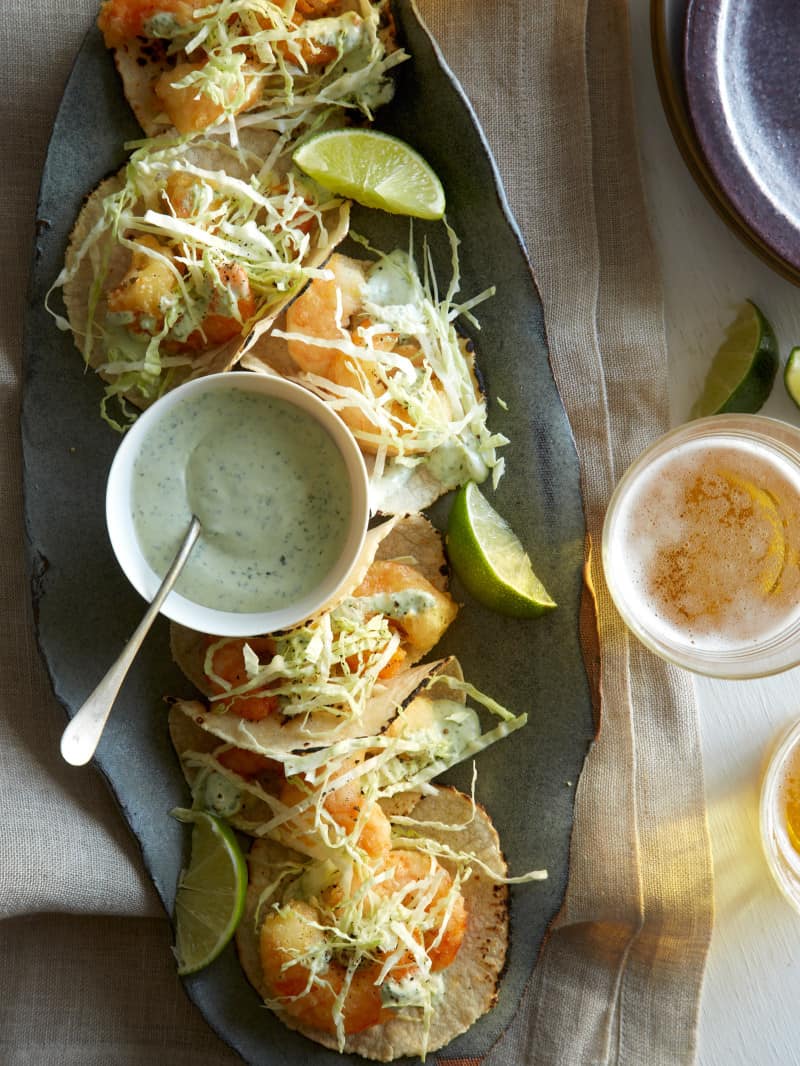 A platter of Beet Battered Shrimp Tacos with some glasses of beer. 