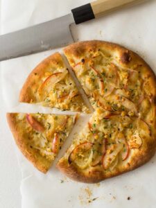A sliced caramelized onion, apple, and bleu cheese pizza.