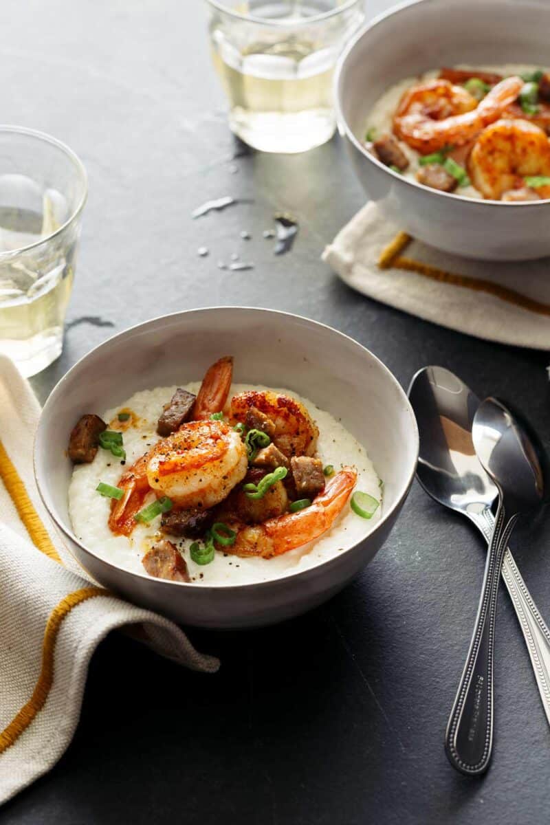 Bowls of shrimp and grits with spoons.