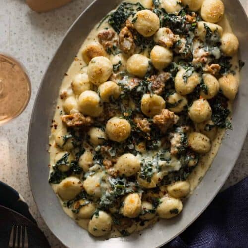 Sausage and kale baked gnocchi on an oval platter.
