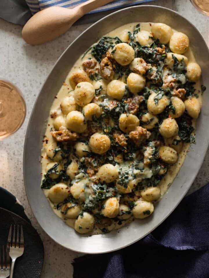 Sausage and kale baked gnocchi on an oval platter.