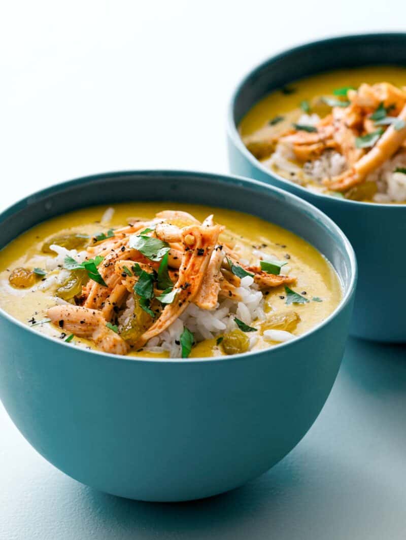 Close up of our Mulligatawny soup recipe topped with rice, chicken, golden raisins and cilantro. 