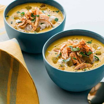 Bowls of one pot chicken mulligatawny soup with a spoon.