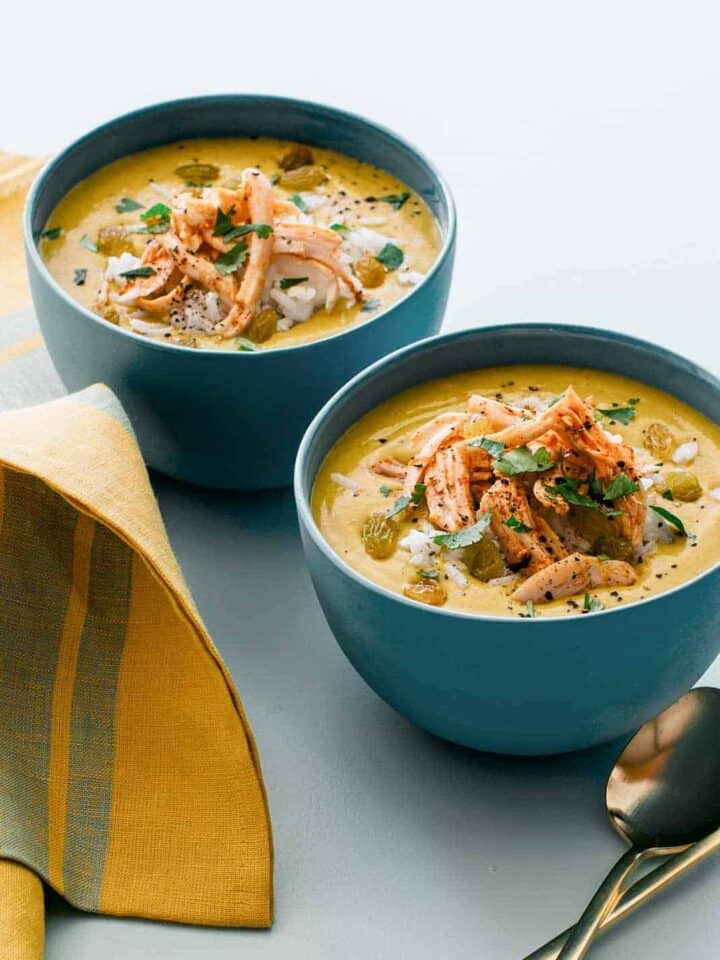 Bowls of one pot chicken mulligatawny soup with a spoon.