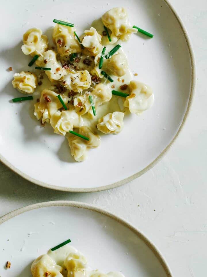 Plates of caramelized apple and herb fiocchi with gorgonzola cream sauce.