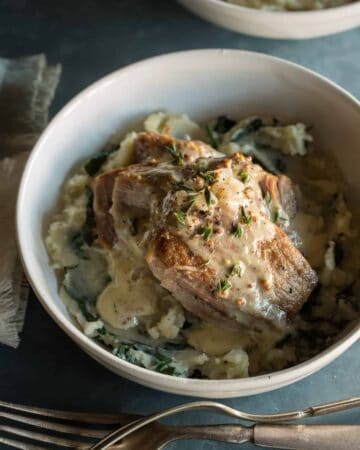 Milk braised pork shoulder over browned butter colcannon in a bowl.