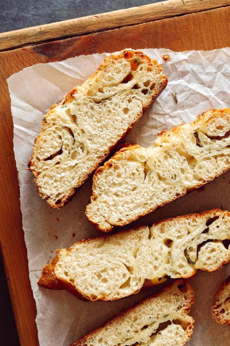 Slices of cheesy roasted garlic and herb pane bianco.