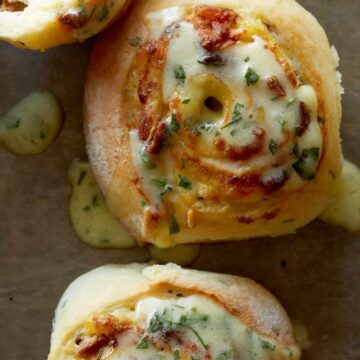 A close up of savory breakfast rolls drizzled in béarnaise.
