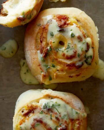 A close up of savory breakfast rolls drizzled in béarnaise.