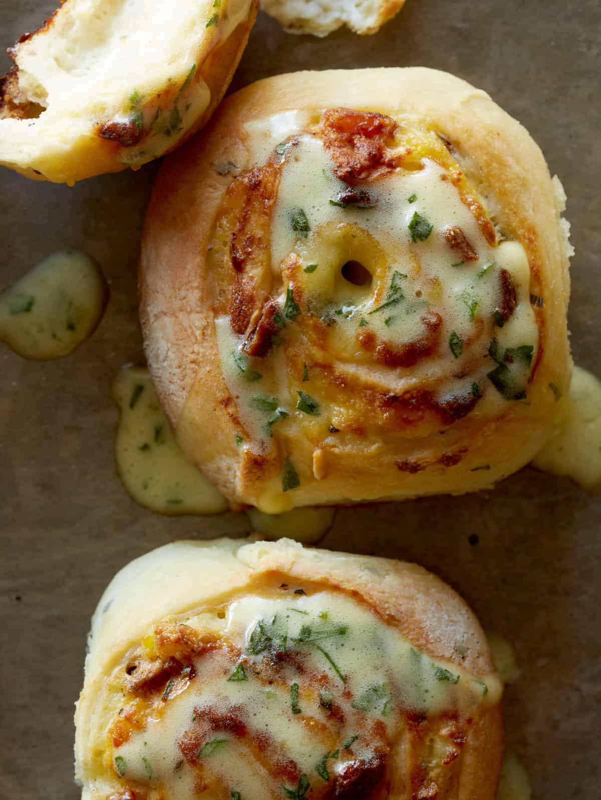 A close up of savory breakfast rolls drizzled in béarnaise.