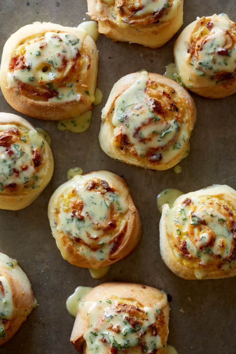 A close up of savory breakfast rolls topped with béarnaise sauce.