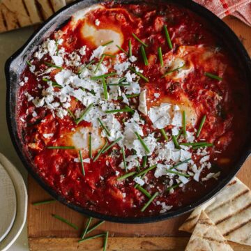 White beans and spinach shakshuka in a skillet.