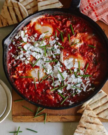 White beans and spinach shakshuka in a skillet.
