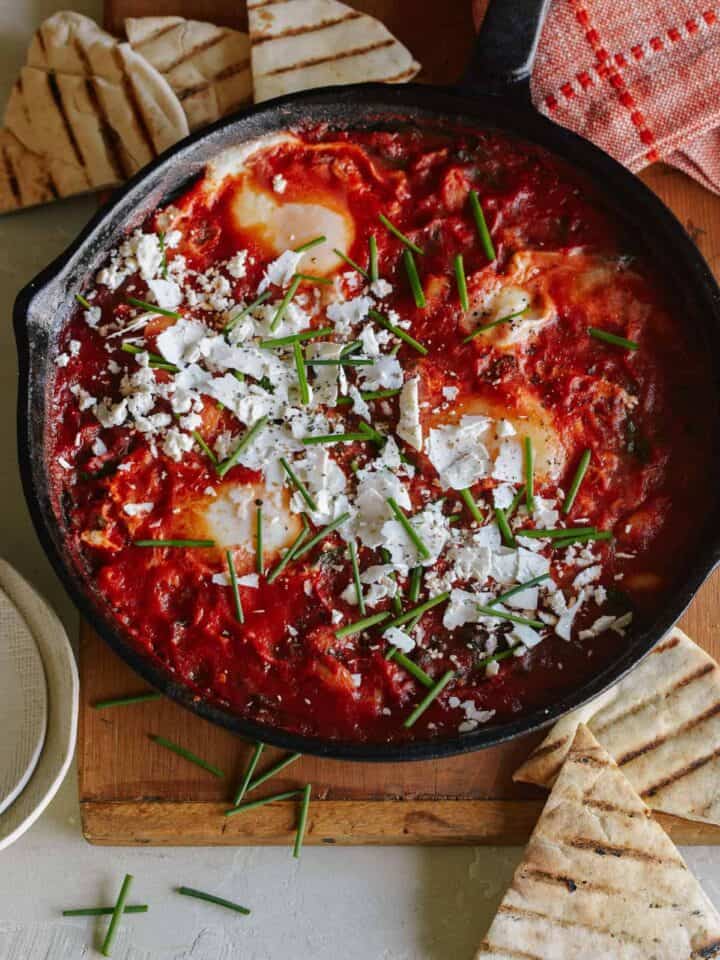 White beans and spinach shakshuka in a skillet.