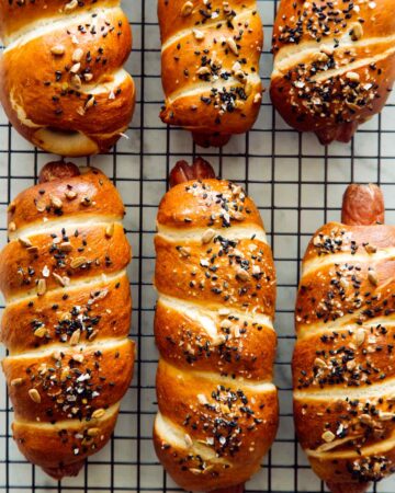 A close up of pretzel dogs on a cooling rack.
