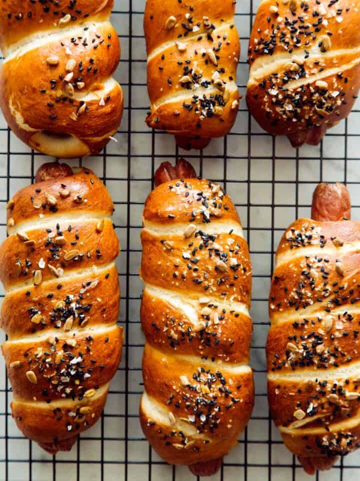A close up of pretzel dogs on a cooling rack.