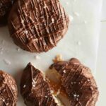 A close up of salted twix cookies with one broken in half.