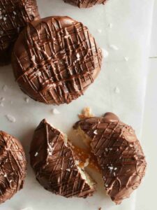 A close up of salted twix cookies with one broken in half.