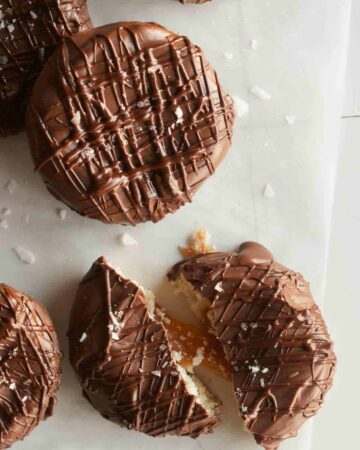 A close up of salted twix cookies with one broken in half.