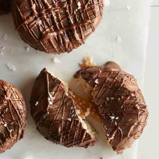 A salted twix cooking broken in half with caramel coming out. 