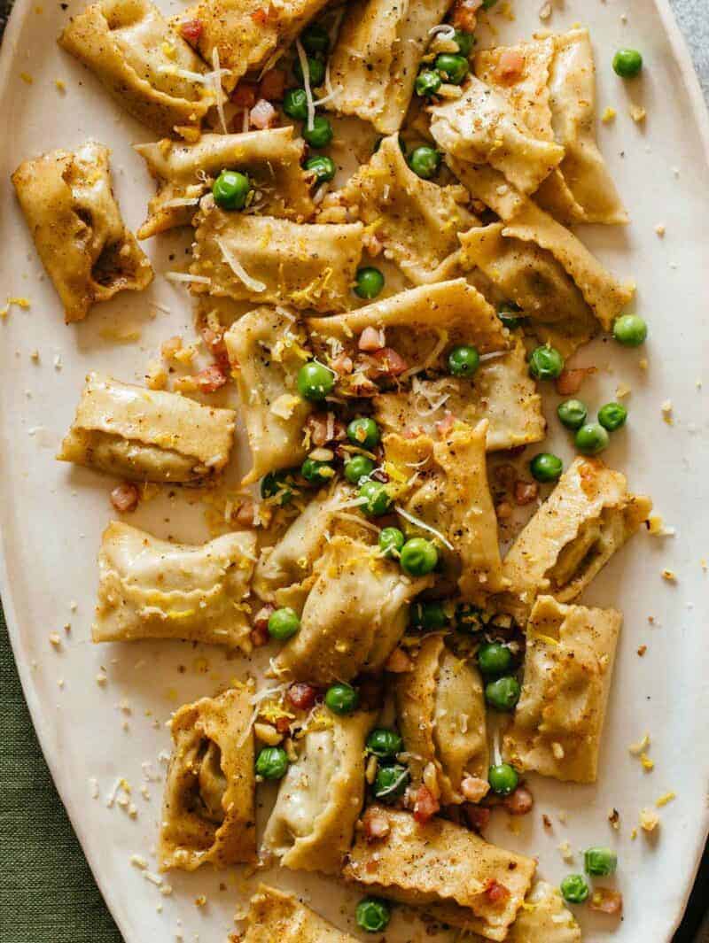 A close up of a plate of creamy sweet pea pesto agnolotti.