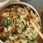 Creamy white cheddar, pancetta, and broccoli stovetop mac and cheese with a wooden spoon.